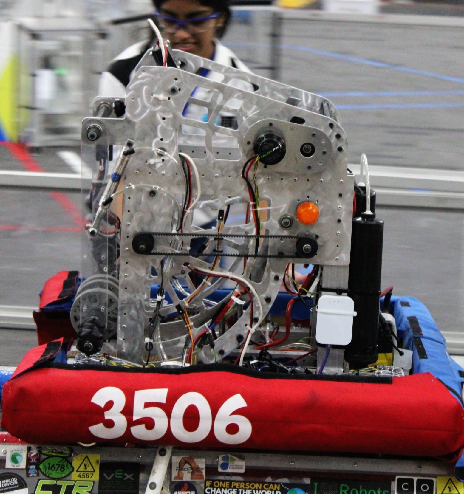 Borealis in the pit with red alliance bumpers, a student working behind it